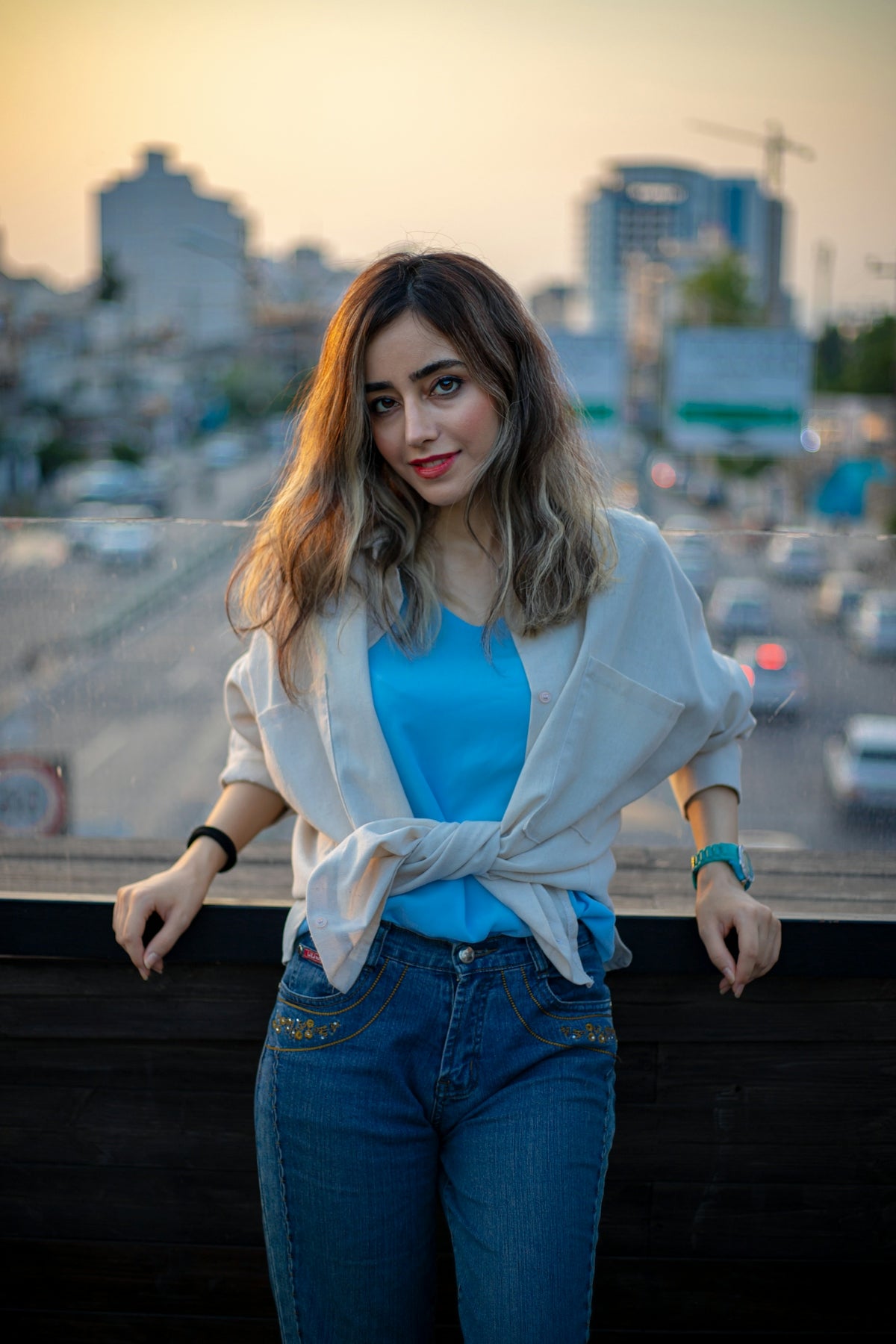 A woman standing on top of a roof next to a street