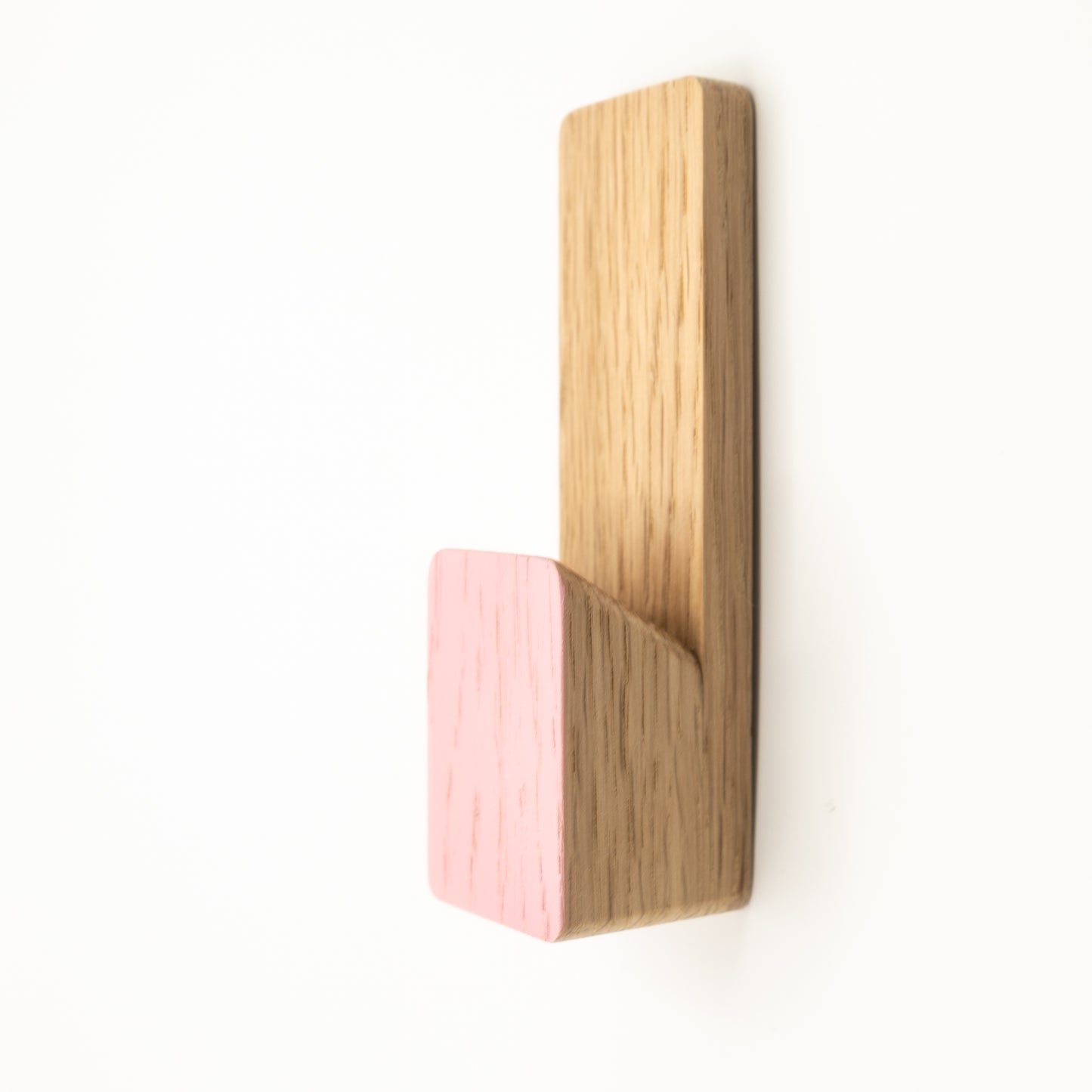 Wooden wall hook with pink base on a white background